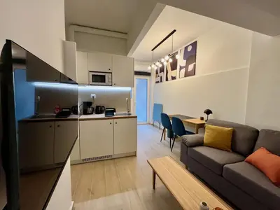 a living room with a couch and a kitchen at Carlo's Apartment in Athens