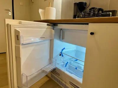 an empty refrigerator with its door open in a kitchen at Carlo's Apartment in Athens