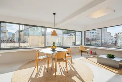 a dining room with a table and chairs and large windows at An Interior in Its Purest Form in Athens