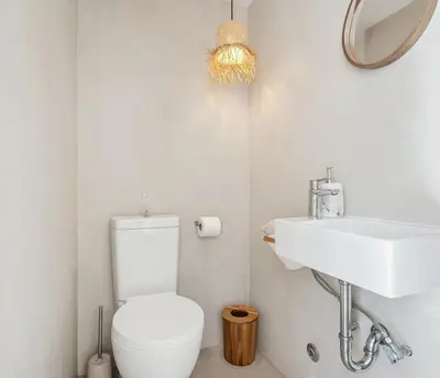 a bathroom with a white toilet and a sink at Living Beyond Design in Athens