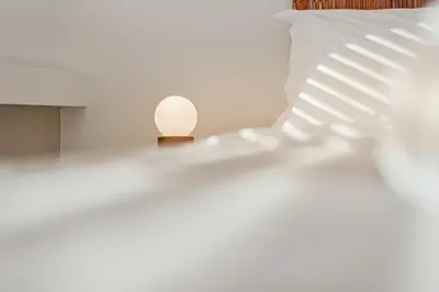 a white lamp sitting on a table next to a pillow at Living Beyond Design in Athens