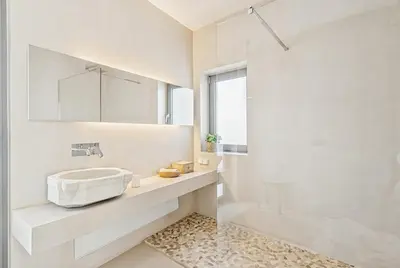a white bathroom with a sink and a mirror at Living Beyond Design in Athens