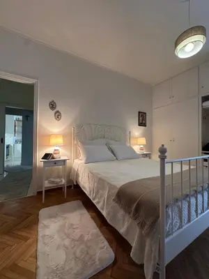 a bedroom with a bed and a table with two lamps at BLU apartment Piraeus Marina Zeas in Piraeus