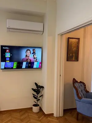 a flat screen tv on a wall in a living room at BLU apartment Piraeus Marina Zeas in Piraeus