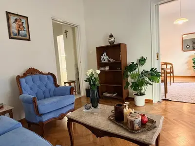 a living room with a blue chair and a table at BLU apartment Piraeus Marina Zeas in Piraeus