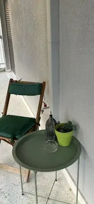 a green table with a bowl and a chair at BLU apartment Piraeus Marina Zeas in Piraeus