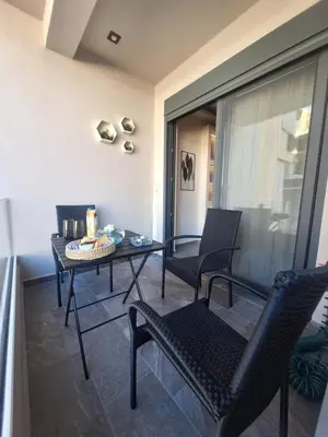 a balcony with two chairs and a table and a table at Sunshine houses one in Athens