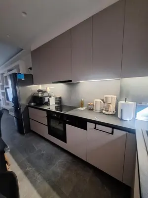 a kitchen with white cabinets and a counter top at Sunshine houses one in Athens