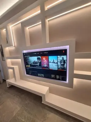 a large flat screen tv on a wall at Sunshine houses one in Athens