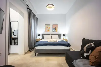 a bedroom with a bed and a couch at Modern Studio l King Bed & Work Corner in Athens