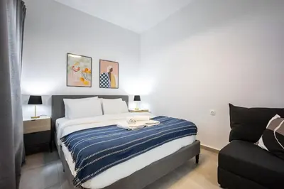 a bedroom with a bed with a blue and white striped blanket at Modern Studio l King Bed & Work Corner in Athens