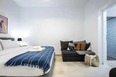 a bedroom with a bed and a couch at Modern Studio l King Bed & Work Corner in Athens