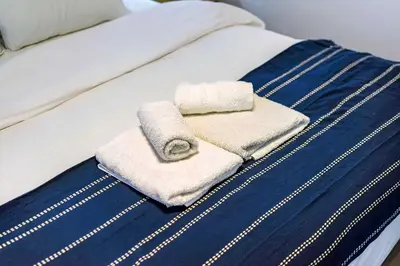 a bed with two towels on top of it at Modern Studio l King Bed & Work Corner in Athens