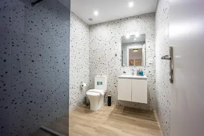 two pictures of a bathroom with a toilet and a sink at Modern Studio l King Bed & Work Corner in Athens