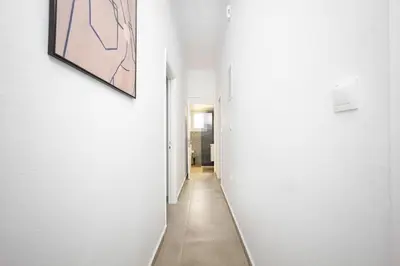 a hallway with white walls and a painting on the wall at Bright Cozy 2BR l Private Balcony & Work Corner in Athens