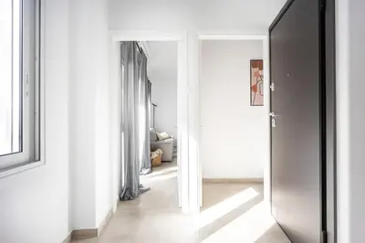 a hallway with white walls and an open door at Bright Cozy 2BR l Private Balcony & Work Corner in Athens