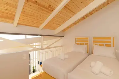 two beds in a room with wooden ceilings at Alter Athens Downtown in Athens