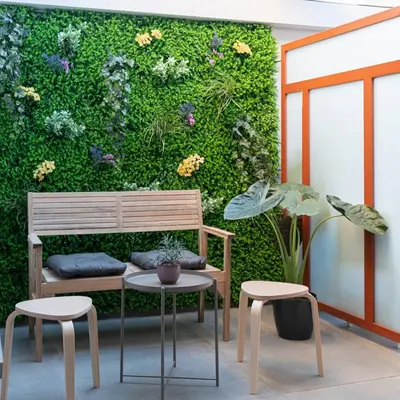a bench and two chairs in front of a green wall at Alter Athens Downtown in Athens