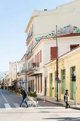 a man crossing a street with a dog on a crosswalk at Alter Athens Downtown in Athens