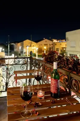 a bottle of wine and two glasses on a wooden bench at Alter Athens Downtown in Athens
