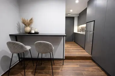 a kitchen with two stools and a counter with a counter top at Piraeus Port Luxury Suites No3 in Piraeus