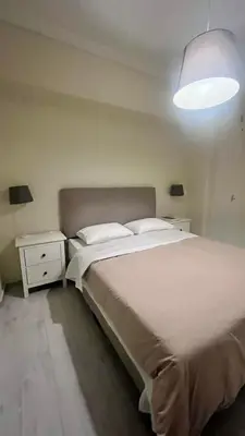 a bedroom with a large white bed and a lamp at Sunny Homes Vournazou in Athens