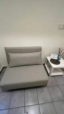 a bed sitting on a tiled floor with a side table at Sunny Homes Vournazou in Athens