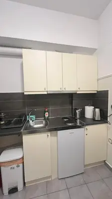 a kitchen with white cabinets and a sink at Sunny Homes Vournazou in Athens