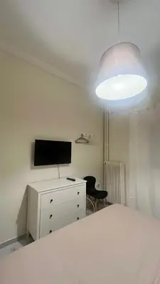 a bedroom with a bed and a tv and a desk at Sunny Homes Vournazou in Athens