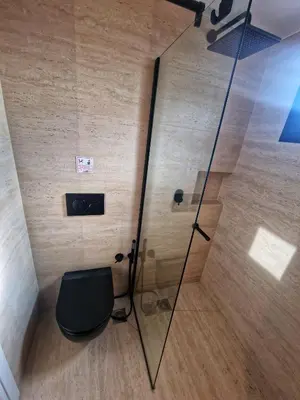 a bathroom with a toilet and a glass shower at Athens Center Apartment with Private Jacuzzi in Athens