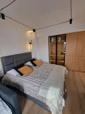 a bedroom with a large bed with white sheets and orange pillows at Athens Center Apartment with Private Jacuzzi in Athens