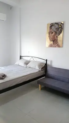 a bedroom with a bed and a bench with a painting at Афіни Лофт in Piraeus