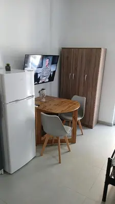 a kitchen with a wooden table and a refrigerator at Афіни Лофт in Piraeus