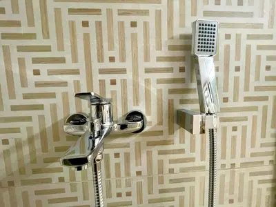 a bathroom with a shower and a hair dryer on a wall at Athenian blue in Athens