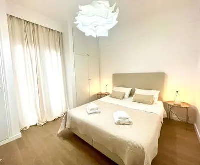 a bedroom with a large white bed with a chandelier at Athenian blue in Athens