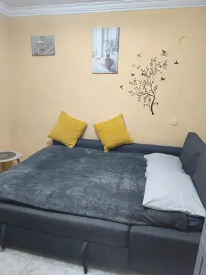 a bedroom with a blue bed with yellow pillows at Kipsely room in Athens
