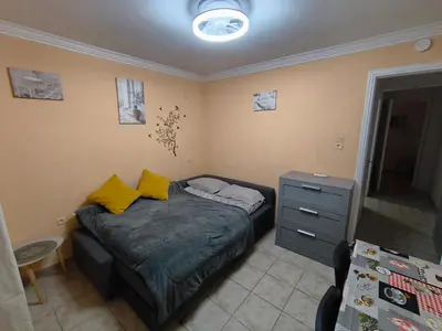 a small bedroom with a bed with yellow pillows at Kipsely room in Athens