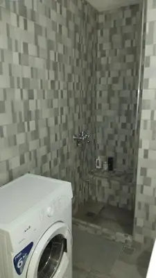a washing machine in a bathroom with a shower at Kipsely room in Athens