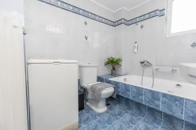 a bathroom with a toilet and a tub and a sink at Raise Glyfada Sky Residence in Athens
