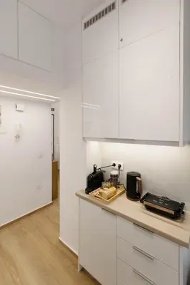 a kitchen with white cabinets and a counter top at Athens Vibes in Kipseli in Athens