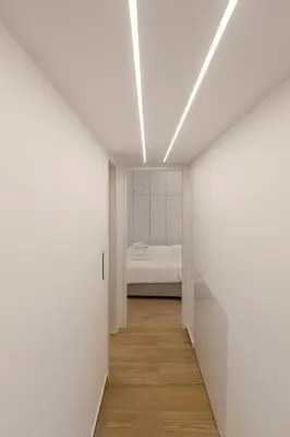 a hallway with white walls and a bed in a room at Athens Vibes in Kipseli in Athens