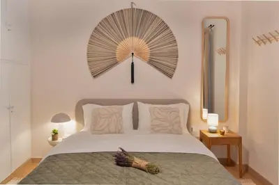 a large fan hangs above a bed in a bedroom at Stylish Modern apartment, 10' from the center! in Athens