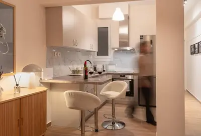a kitchen with a counter and two stools in it at Stylish Modern apartment, 10' from the center! in Athens