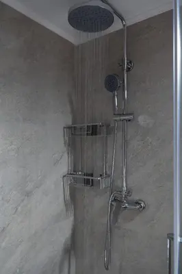 a shower with a shower head in a bathroom at Stylish Modern apartment, 10' from the center! in Athens