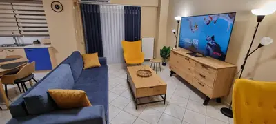 a living room with a blue couch and a flat screen tv at Dramas17 - PS5 in Piraeus