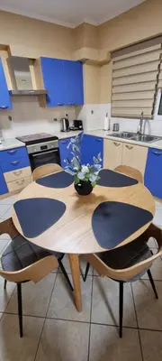 a kitchen with a wooden table and blue cabinets at Dramas17 - PS5 in Piraeus