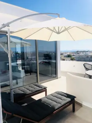 a white umbrella sitting on top of a balcony at Glyfada Amazing Suite with sea view & jacuzzi in Athens