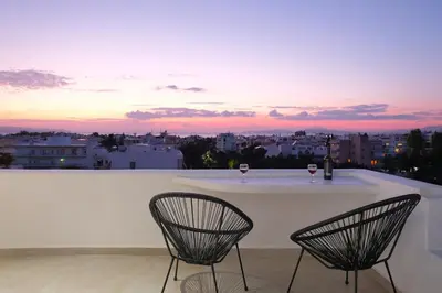 two chairs sitting on a balcony with wine glasses at Glyfada Amazing Suite with sea view & jacuzzi in Athens