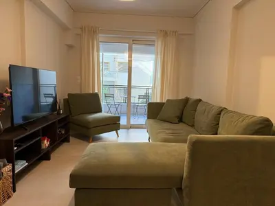 a living room with a couch and a flat screen tv at Estía Cozy City Apartment in Athens