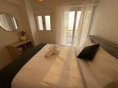 a bedroom with a large white bed with a mirror at Estía Cozy City Apartment in Athens